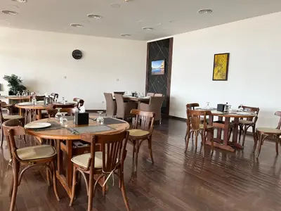 a dining room with wooden tables and chairs at EP1 TWO BEDROOM APARTMENT AT Samarah Resort in Sowayma