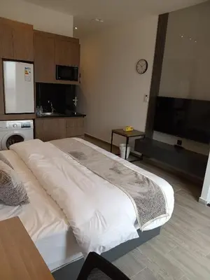 a large white bed in a room with a tv at Alshakreen suites in Amman