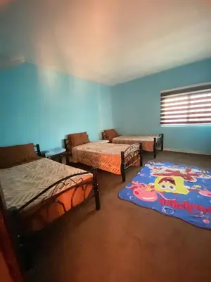 a room with three beds and a window and a window at Magical Rosemary Chalet in Al Mashāriqah
