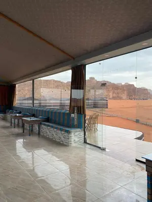 a living room with a couch and a view of the desert at nature camp in Wadi Rum