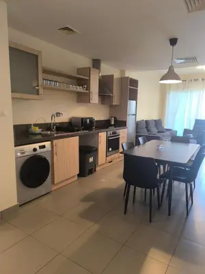 a kitchen and dining room with a table and chairs at E21 Samarah Resort Apartments in Sowayma