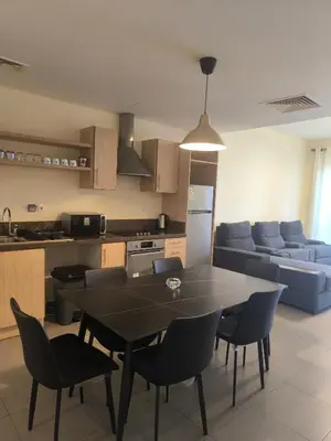 a kitchen and living room with a table and chairs at E21 Samarah Resort Apartments in Sowayma