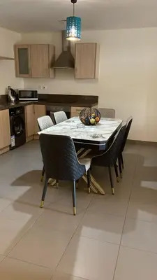 a kitchen with a table and chairs in a room at E03 Samarah Resort Apartments in Sowayma