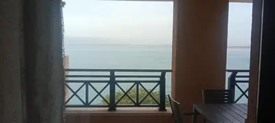 a room with a view of the ocean from a balcony at E03 Samarah Resort Apartments in Sowayma
