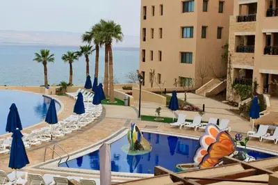 a pool at a hotel with chairs and umbrellas at E03 Samarah Resort Apartments in Sowayma