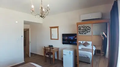 a small room with a bed and a refrigerator at Moab Land Hotel in Madaba