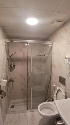a bathroom with a shower and a toilet at Moab Land Hotel in Madaba