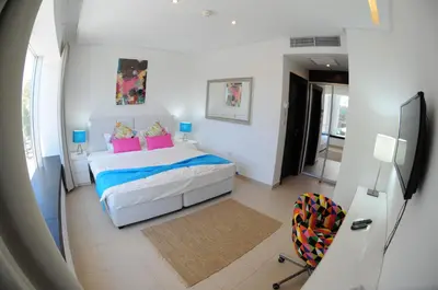 a bedroom with a bed with pink and blue pillows at Prime Hotel in Amman