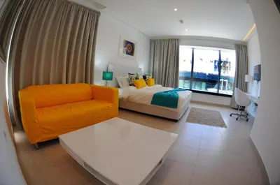 a bedroom with a bed and a couch and a window at Prime Hotel in Amman