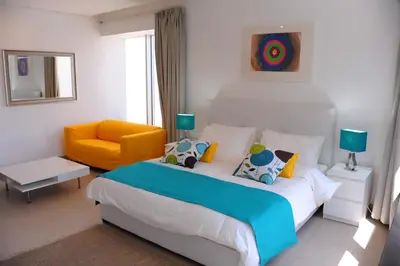 a bedroom with a bed and a yellow chair at Prime Hotel in Amman