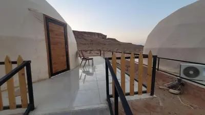 a building with a balcony with a view of the desert at Rum Gonesh Luxury Camp in Wadi Rum