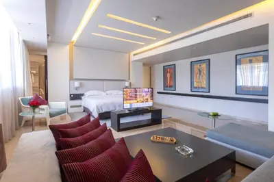 a hotel room with a bed and a living room at The Abdali Boulevard Hotel in Amman