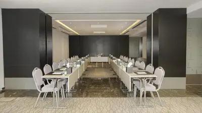 a conference room with a long table and white chairs at The Abdali Boulevard Hotel in Amman