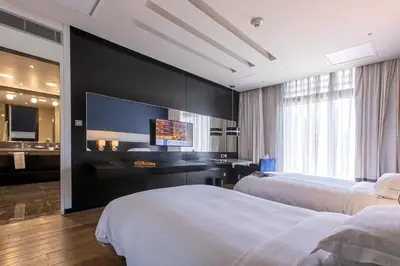 a hotel room with two beds and a flat screen tv at The Abdali Boulevard Hotel in Amman