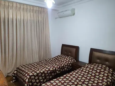 two beds sitting next to each other in a room at Noor Apartment in Amman