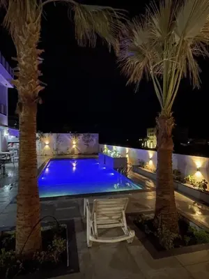 a pool with blue lighting in a resort at night at Deadsea Elite First floor shared swimming pool in Sowayma