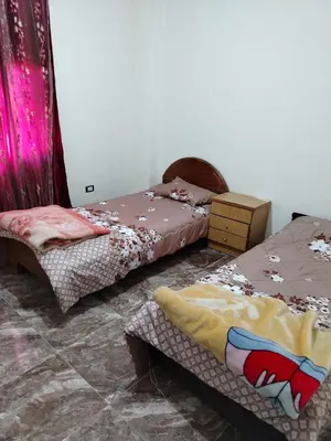 two beds in a room with pink curtains at الشقة العائلية الحديثة familial new flat in Amman