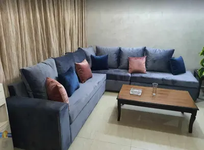 a blue couch in a living room with a coffee table at Shahed Apartment in Amman