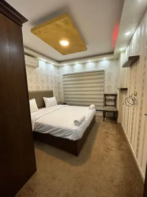 a bedroom with a bed and a chair in it at al-burj apart at 7th circle in Amman