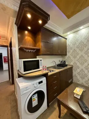 a kitchen with a washing machine and a microwave at al-burj apart at 7th circle in Amman
