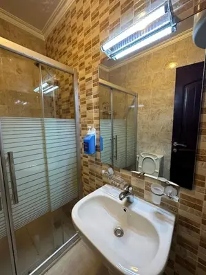 a bathroom with a sink and a glass shower at al-burj apart at 7th circle in Amman