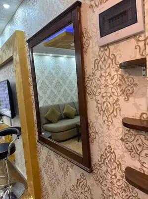 a mirror on a wall with a couch in a room at al-burj apart at 7th circle in Amman