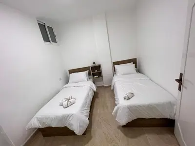 two beds in a room with white sheets and white towels at The guset house in Kerak