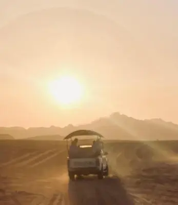 a group of people in a jeep driving through the desert at Wadi Rum Desert Tours and Glamping with Hussein in Wadi Rum