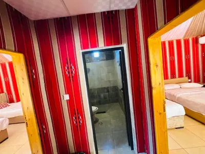 a room with red striped walls and a glass door at Rum Elegant luxury camp in Wadi Rum