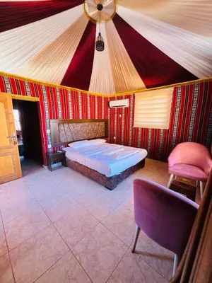 a room with a bed and a tent at Rum Elegant luxury camp in Wadi Rum