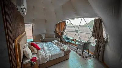 a bedroom with a bed and a window in a boat at Rum Elegant luxury camp in Wadi Rum
