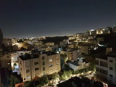 a view of a city at night with lights at Maria Apartment in Amman