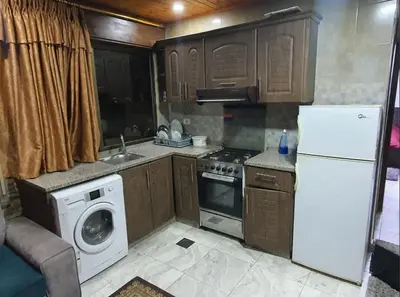 a kitchen with a white refrigerator and a dishwasher at Maria Apartment in Amman