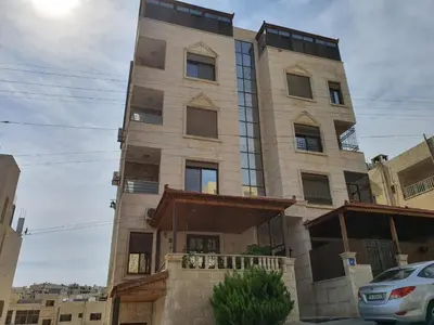 a building in the middle of a street at Maria Apartment in Amman