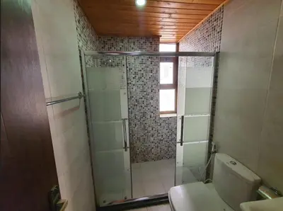 a bathroom with a shower with a toilet and a sink at Maria Apartment in Amman