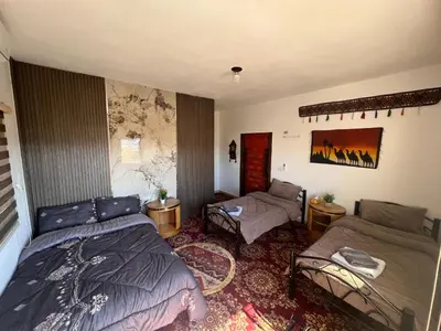 a bedroom with two beds and a couch at Eman house in Wadi Musa