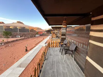 a building with chairs and a view of the desert at Magical desert camp in Disah