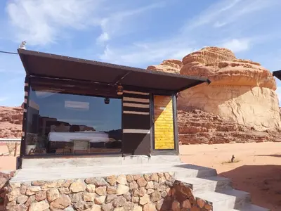 a building in the desert with a rock at Magical desert camp in Disah