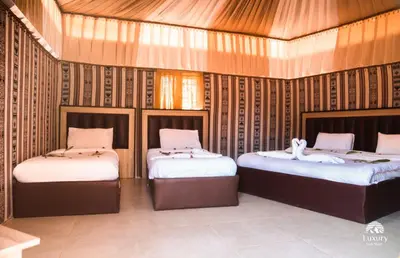 a room with two beds in a room at Magical desert camp in Disah
