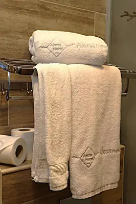 a pile of towels on a towel rack in a bathroom at Alena Boutique Hotel in Aqaba