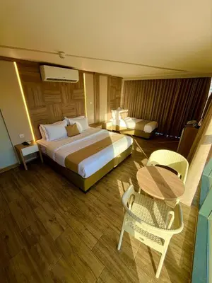 a hotel room with a large bed and a table at Alena Boutique Hotel in Aqaba