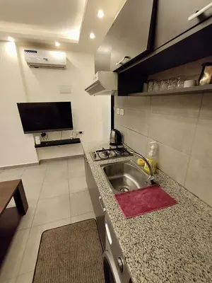 a kitchen with a sink and a stove at Gentle Breeze Studio 3 in Amman