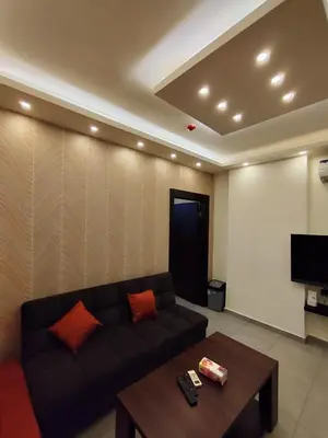a living room with a couch and a table at Gentle Breeze Studio 3 in Amman