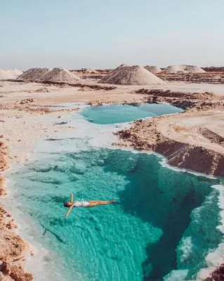 a man swimming in a pool of water in the desert at Tala DeadSea Villa in Sowayma