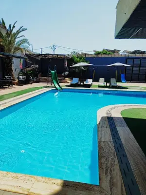 a swimming pool with blue water in a building at Tala DeadSea Villa in Sowayma