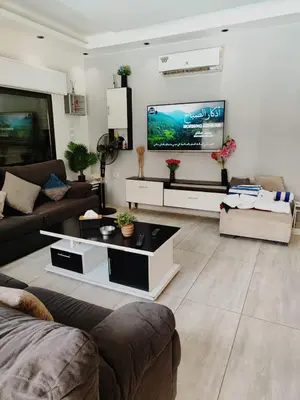a living room with a couch and a flat screen tv at Tala DeadSea Villa in Sowayma
