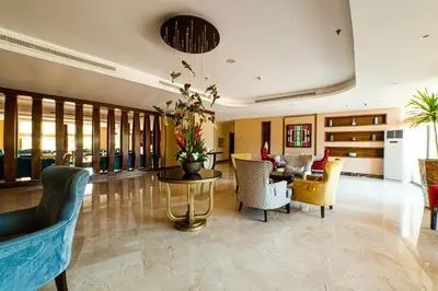a lobby with chairs and a table with flowers on it at Oryx Hotel Aqaba in Aqaba