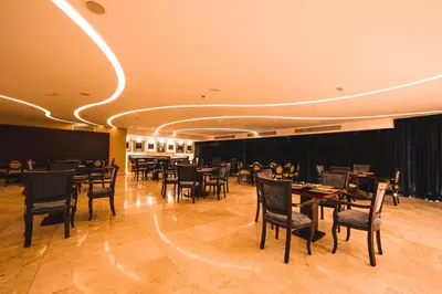 a restaurant with tables and chairs in a room at Oryx Hotel Aqaba in Aqaba