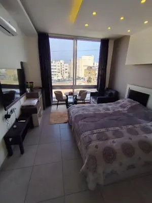 a bedroom with a bed and a large window at Gentle Breeze Studio 2 in Amman