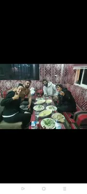 a group of people sitting around a table eating food at Rum Bacific camp in Wadi Rum